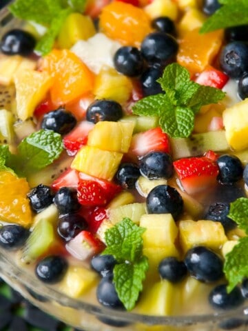 Close up of tropical fruit salad in a glass bowl.