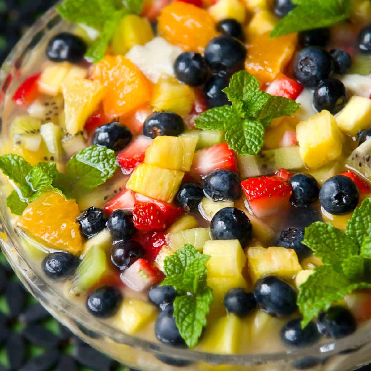 Close up of tropical fruit salad in a glass bowl.