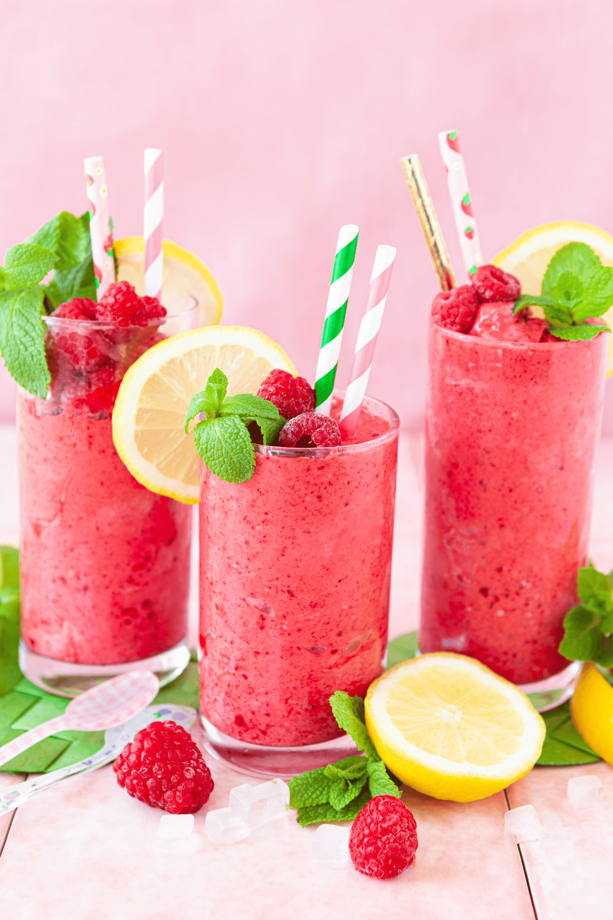 Glasses of a party alcoholic beverage garnished with mint and fresh fruits.