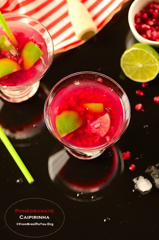 vodka pomegranate cocktail in glasses garnished with lime wedges. 