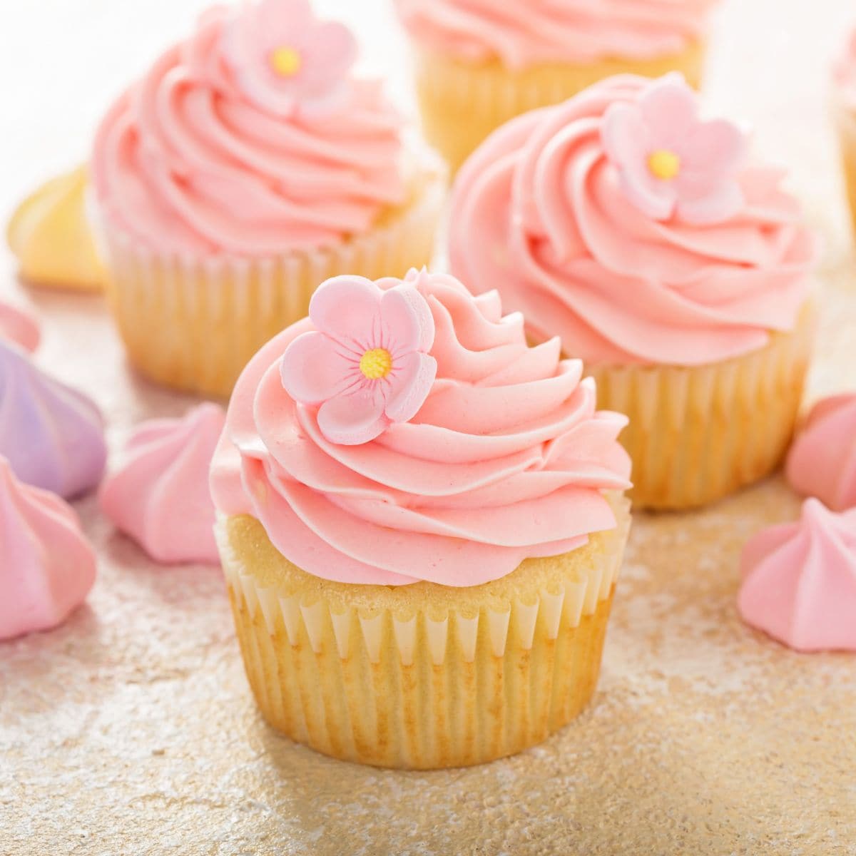 Passion fruit cupcakes filled with mousse and topped with a pink frosting.