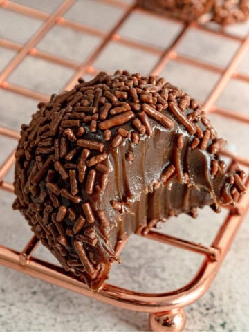 A bitten brigadeiro on a rack.