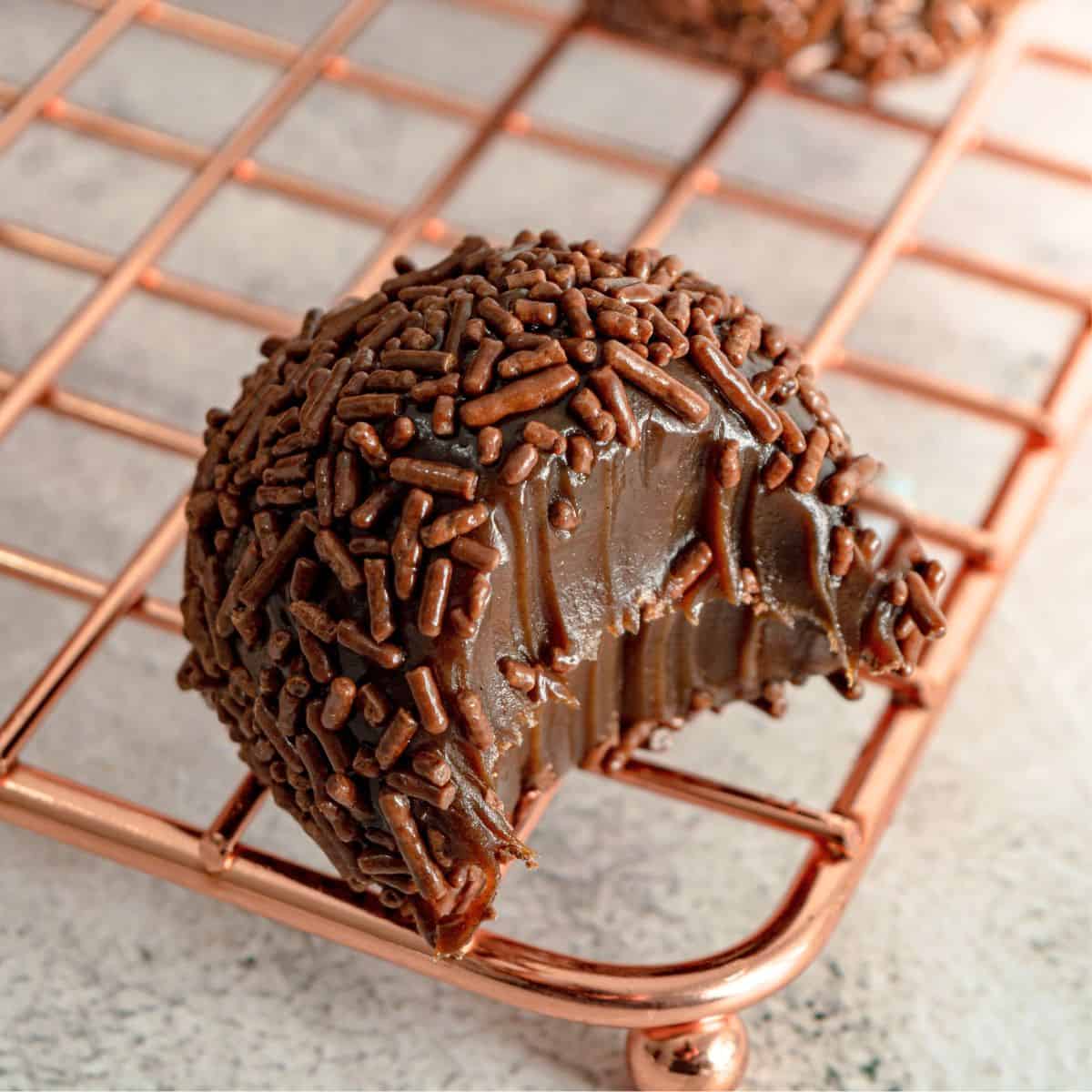 A bitten brigadeiro on a rack.