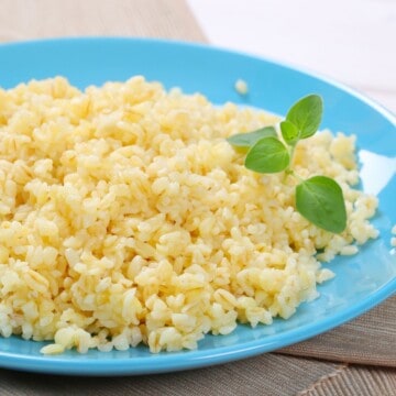 Close up of half plate with cooked pearl barley, which contains beta-glucans that may help with weight loss, lower cholesterol, improve insulin resistance, and more.